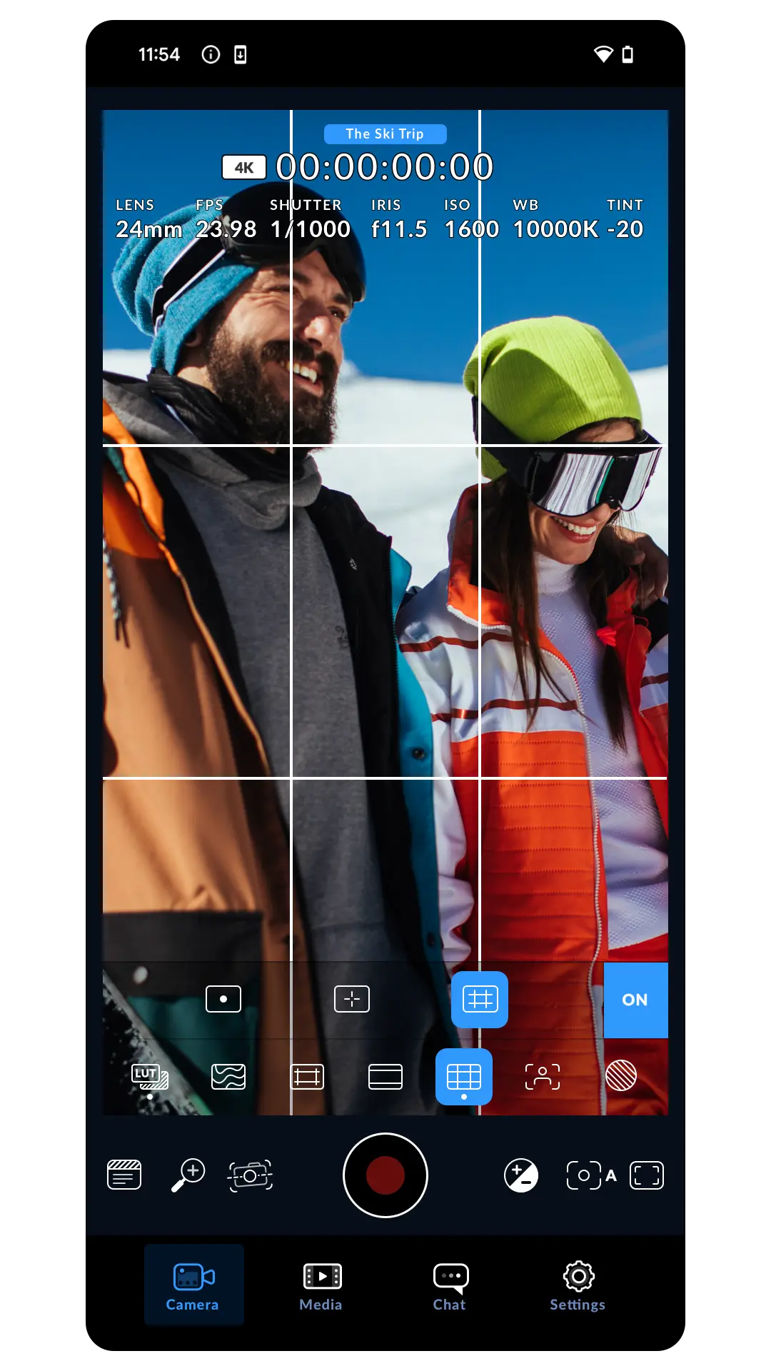 Camera preview of two skiers with a rule of thirds grid overlay and the guides toolbar open showing LUT, zebra and grid toggles set to ON