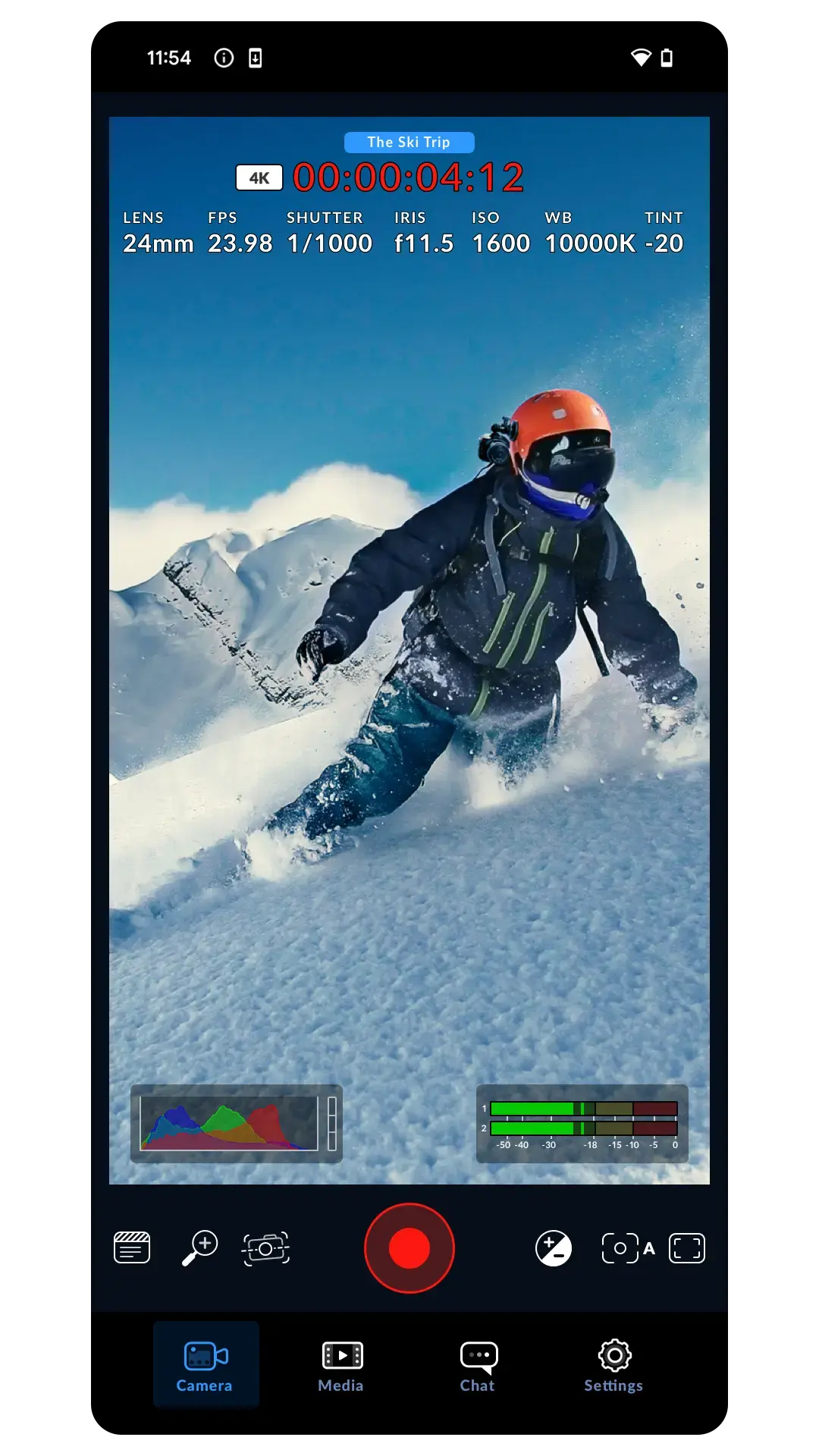 The Blackmagic Camera app mid-recording, showing a red 00:00:04:12 timecode and a 4K badge above a control strip reading LENS 24mm, FPS 23.98, SHUTTER 1/1000, IRIS f11.5, ISO 1600, WB 10000K and TINT -20, over a live viewfinder of a skier, with an RGB histogram and two-channel audio meters along the bottom.